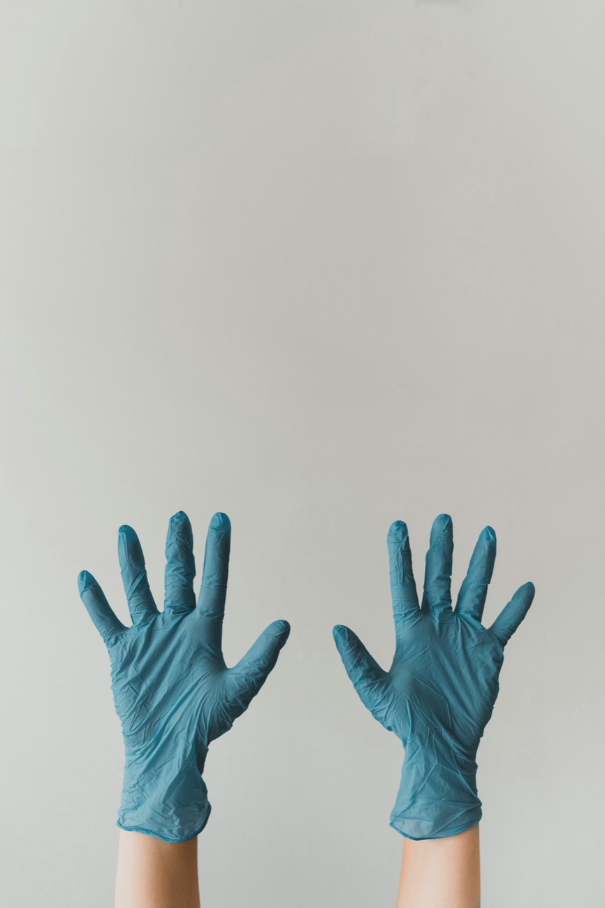 Deux mains gantées levées, prêtes à opérer.